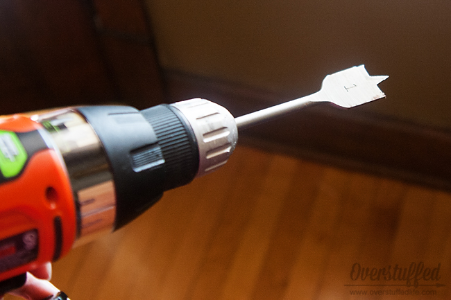 Use the 1 inch drill bit to drill a hole large enough for your plugs to go through.
