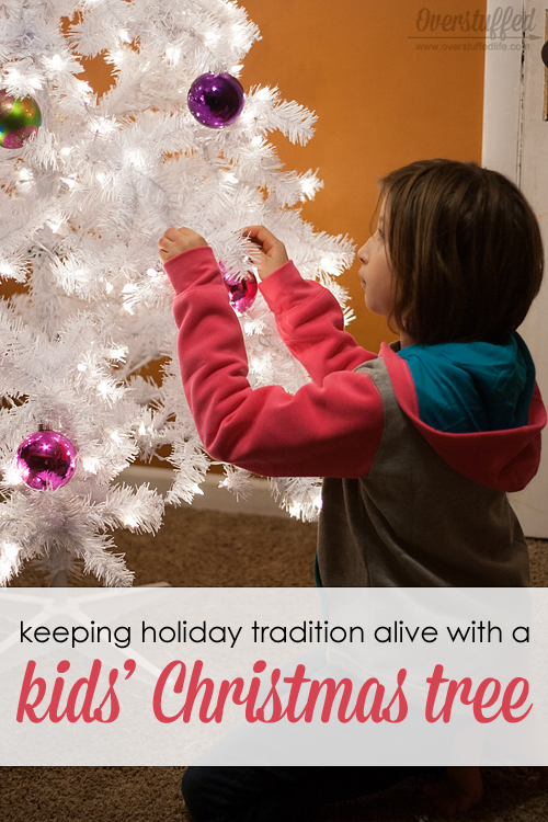 Two brothers are helping to decorate the Christmas tree with red