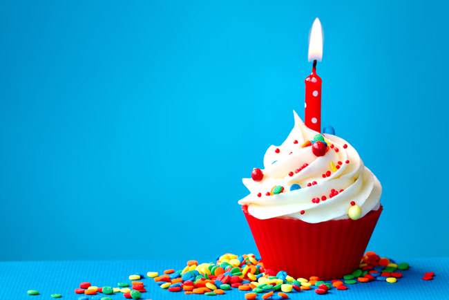 Cupcake on blue background with sprinkles.