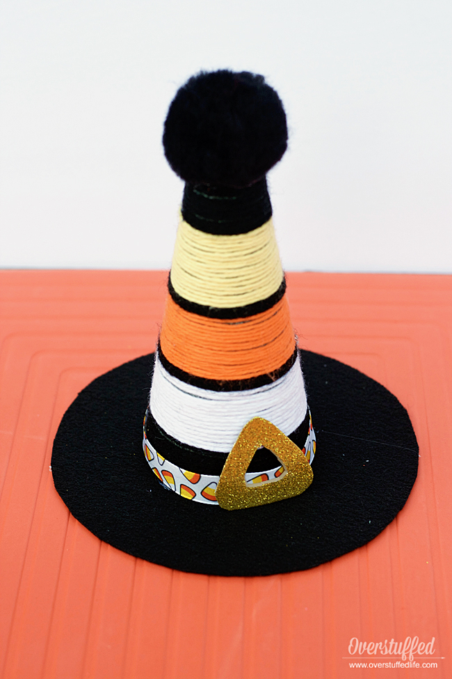 This adorable candy corn witch hat is made out of yarn, felt, ribbon, and craft foam. Make one to add to your Halloween decor today!